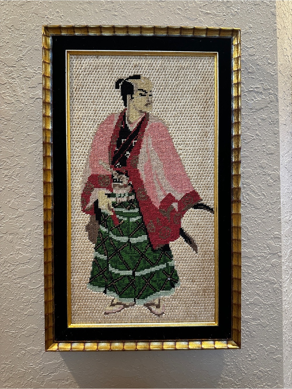 This framed needlepoint artwork appears to depict a traditional Japanese samurai